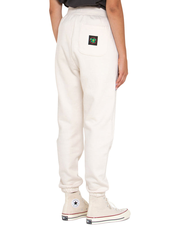 white relaxed fit track pant with front embroidered badge, elasticated drawstring waist, 100% organic cotton 450gm brushed back fleece fabrication with a heavy enzyme stone wash