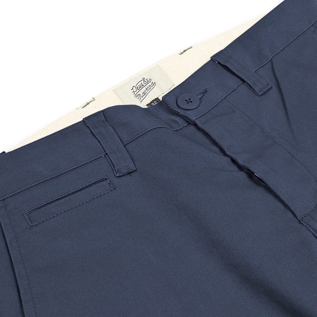 Navy slim fit pant with zip fly closure, back welt pockets, coin pocket detail, 63% poly 34% cotton 3% spandex twill fabrication with a garment wash